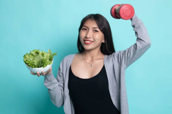 Healthy Asian woman with dumbbells and salad.