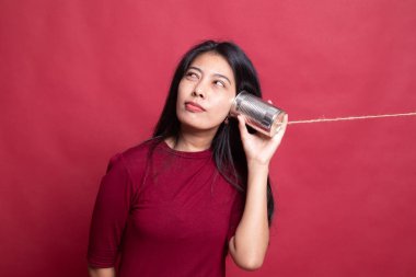 Teneke kutu telefon ile genç Asyalı kadın.