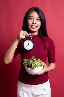 Saat ve salata ile genç Asyalı kadın.