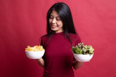 Patates kızartması ve salata ile genç Asyalı kadın.