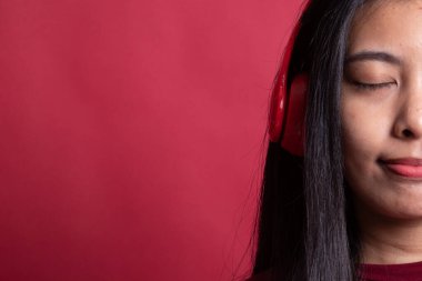 Güzel Asyalı kız kulaklıklarıyla müzik dinliyor..