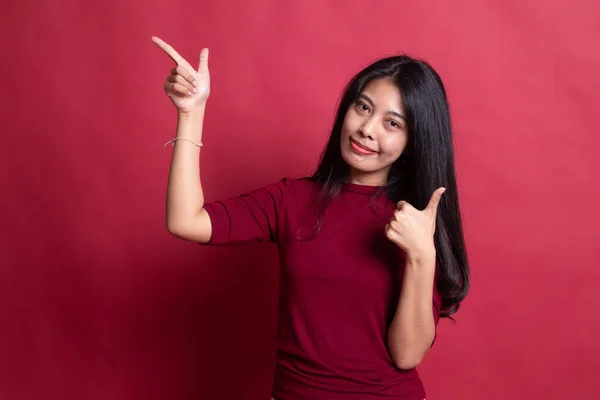 Wanita muda Asia menunjuk dan jempol atas . — Stok Foto