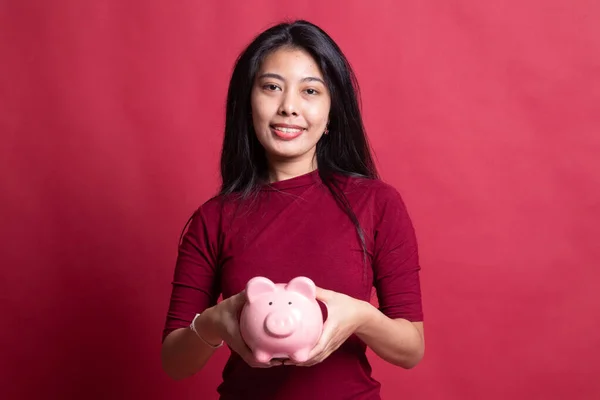 Młoda kobieta azjatyckich w banku moneta świnia. — Zdjęcie stockowe