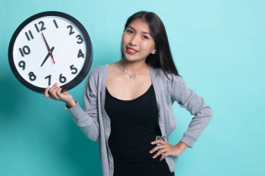 Saati olan genç Asyalı kadın..