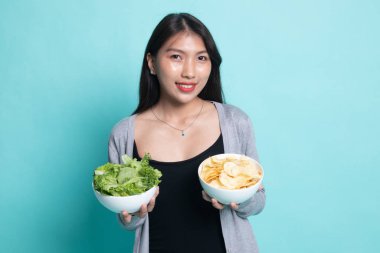 Patates kızartması ve salata ile genç Asyalı kadın.