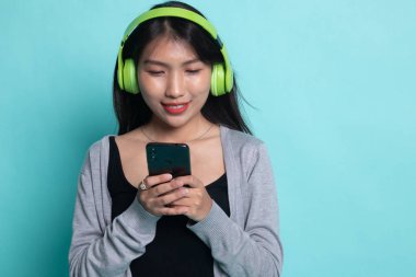 Güzel Asyalı kız kulaklıklarıyla müzik dinliyor..