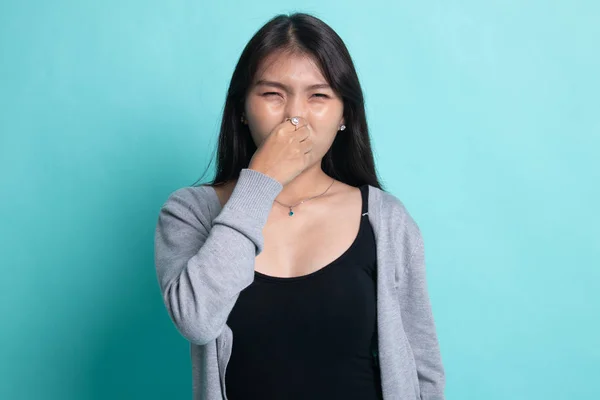 Jonge Aziatische vrouw met haar neus vanwege een slechte geur. — Stockfoto