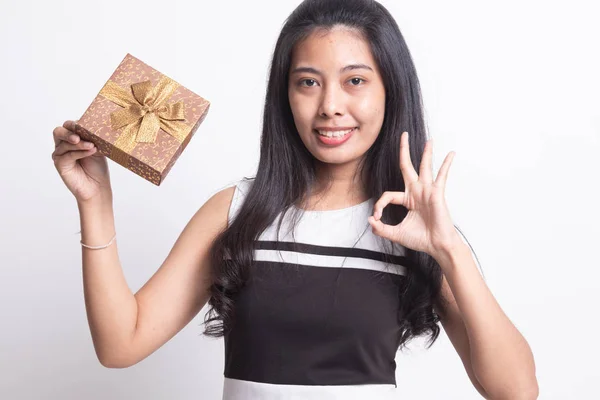 Jovem mulher asiática mostrar OK com uma caixa de presente . — Fotografia de Stock