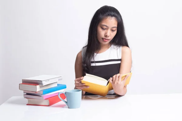 Ung asiatisk kvinna läsa en bok med kopp kaffe. — Stockfoto