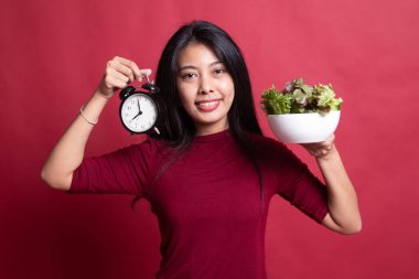 Saat ve salata ile genç Asyalı kadın.