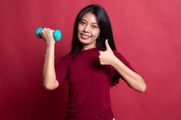 Healthy Asian woman thumbs up with dumbbells.