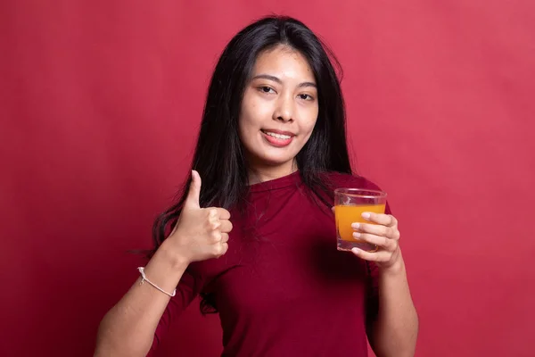 Jeune femme asiatique pouces vers le haut boisson jus d'orange . — Photo