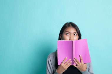 Bir kitapla genç Asyalı kadın kapak yüzü.