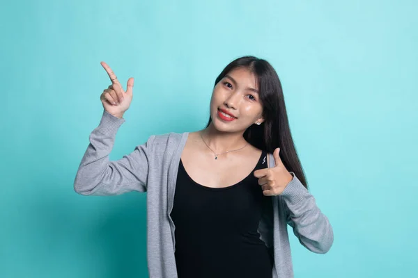 Молодая азиатка показывает пальцем вверх . — стоковое фото
