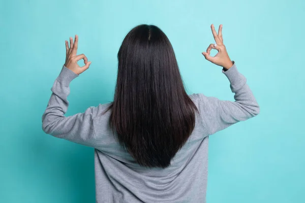 Indietro vista di asiatico donna spettacolo doppio ok mano segno . — Foto Stock