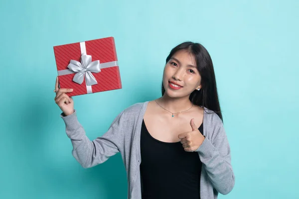 Jovem mulher asiática polegares para cima com uma caixa de presente . — Fotografia de Stock