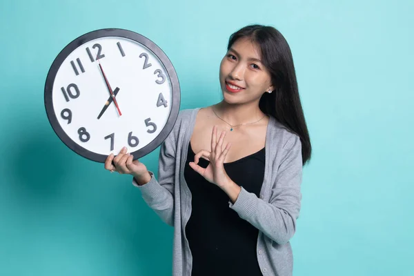 Joven asiática show OK con un reloj . —  Fotos de Stock