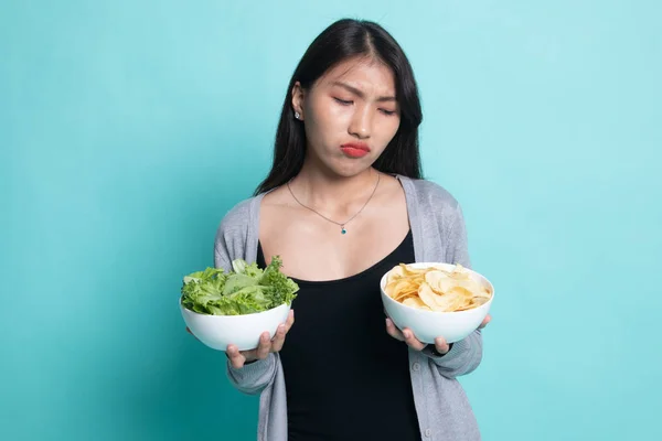 Ung asiatisk kvinna med potatischips och sallad. — Stockfoto