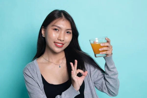 젊은 아시아 여자 쇼 확인 마시는 오렌지 주스. — 스톡 사진