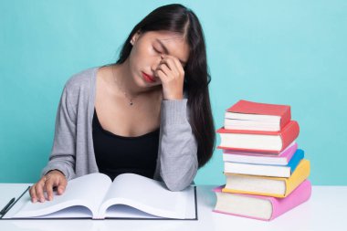 Yorgun Asyalı kadın baş ağrısı okuma sekmesinde kitaplarla bir kitap aldım.