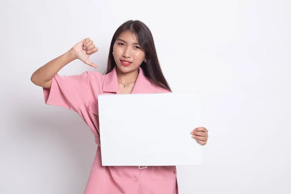 Ung asiatisk kvinna visar tummen ner med vit blank skylt. — Stockfoto