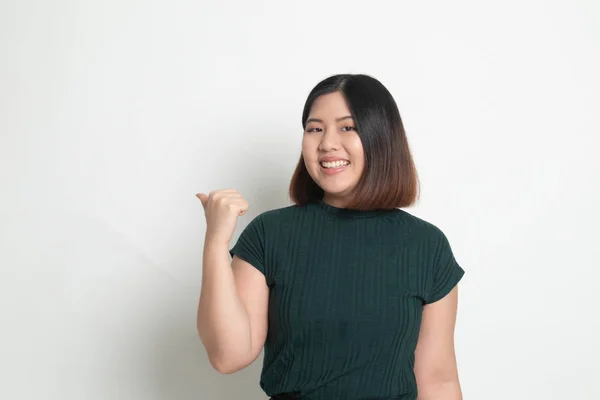Ung asiatisk kvinna leende och peka på kopiera utrymme med tummen — Stockfoto