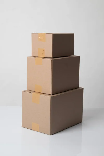 Pile of various size taped up  cardboard boxes — Stockfoto