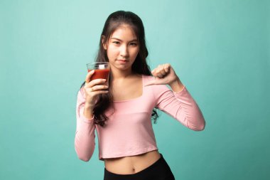 Genç Asyalı kadın, arka planda domates suyundan nefret ediyor.