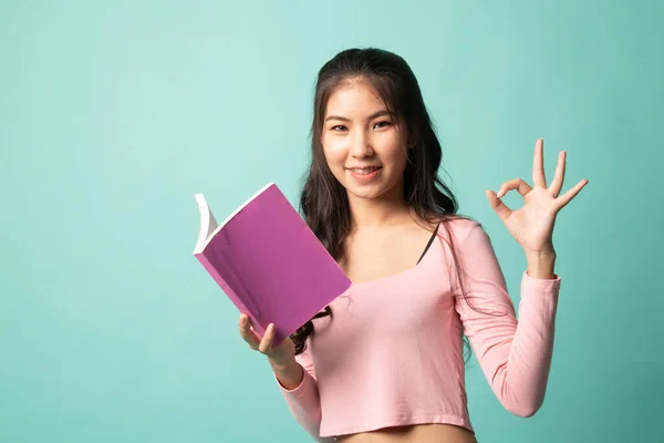 Junge Asiatische Frau Zeigen Mit Einem Buch Über Cyan Hintergrund — Stockfoto