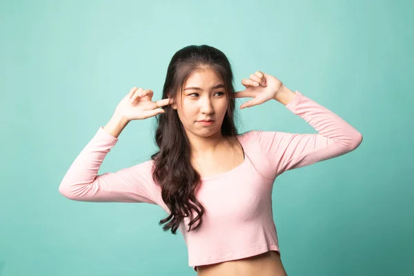 Молода Жінка Азії Блокує Обидва Вуха Пальцем Цианському Фоні — стокове фото