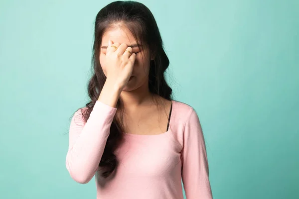 Young Asian woman got sick and  headache on cyan background