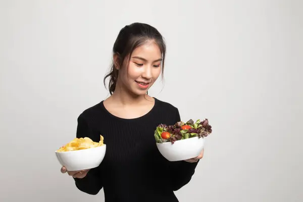 Junge Asiatische Frau Mit Kartoffelchips Und Salat Auf Weißem Hintergrund — Stockfoto