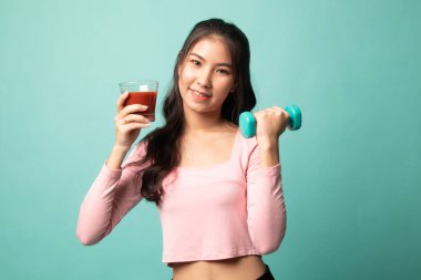 Cyan arka planında dambıl ve domates suyu olan sağlıklı bir Asyalı kadın.