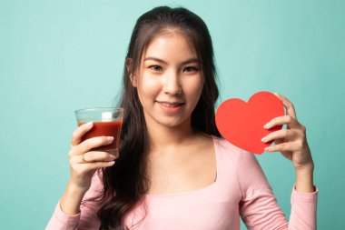 Domates suyu ve kırmızı kalpli genç Asyalı kadın.