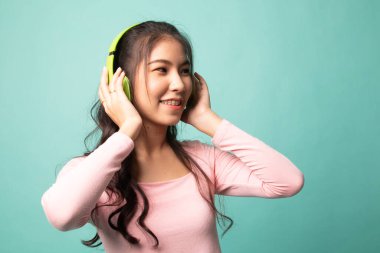 Güzel Asyalı kız kulaklıklarıyla müzik dinliyor.