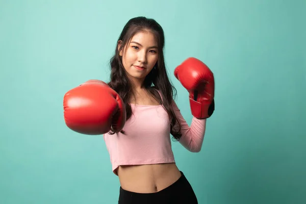 亚洲年轻女子 背景为青色 戴着红色拳击手套 — 图库照片