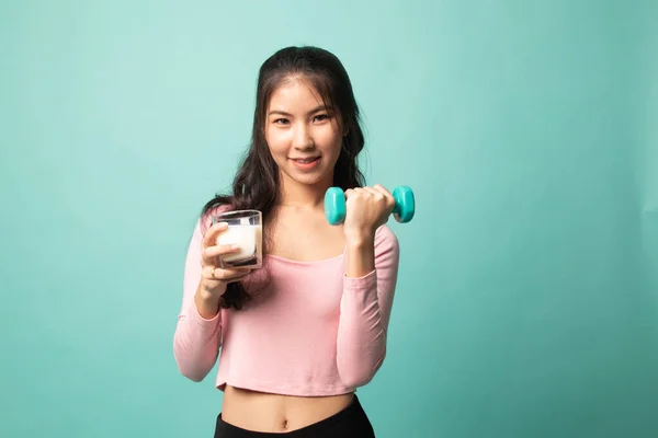 健康的亚洲女人在青色背景下喝着一杯牛奶和哑铃 — 图库照片