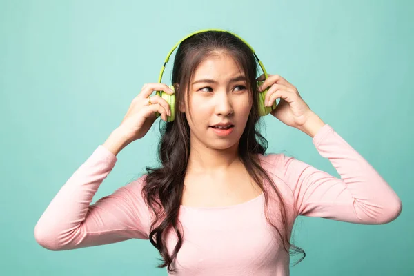 太吵了 年轻的亚洲女人的肖像 手持耳机 在青色背景下做出不快乐的脸 — 图库照片