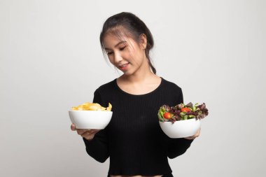 Patates cipsi ve beyaz zemin üzerine salata ile genç Asyalı kadın