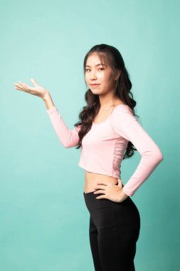 Cyan arka planında eli olan genç bir Asyalı kadın.