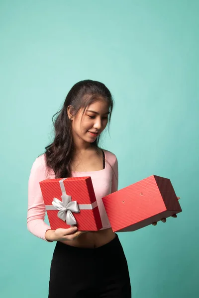 年轻的亚洲女人打开了一个背景为青色的礼品盒 — 图库照片