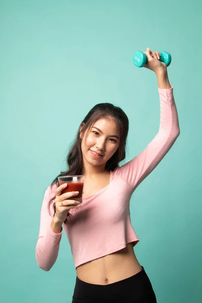 年轻健康的亚洲女人 背景是青色的哑铃和番茄汁 — 图库照片