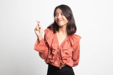 Güzel genç Asyalı kadın çapraz parmak beyaz arka plan üzerinde