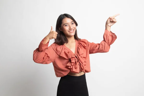 若いアジア女性ポイントと白い背景の上の親指 — ストック写真