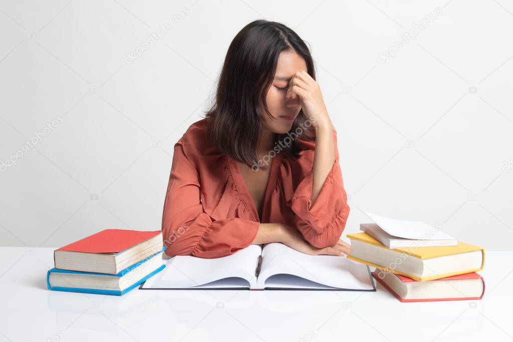 Exhausted Asian woman got headache read a book with books on table on white background