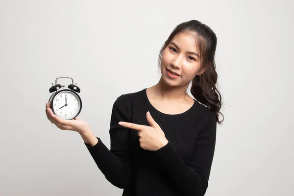 年轻的亚裔女子点到白色背景上的时钟 — 图库照片
