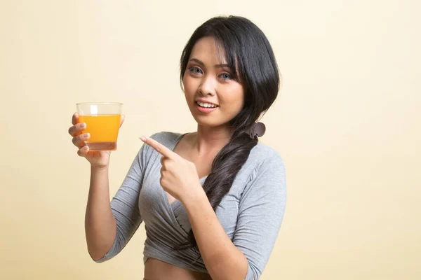 Jovem Mulher Asiática Apontar Para Suco Laranja Fundo Bege — Fotografia de Stock