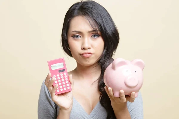 Unhappy Asian Woman Calculator Piggy Bank Beige Background — Stock Photo, Image