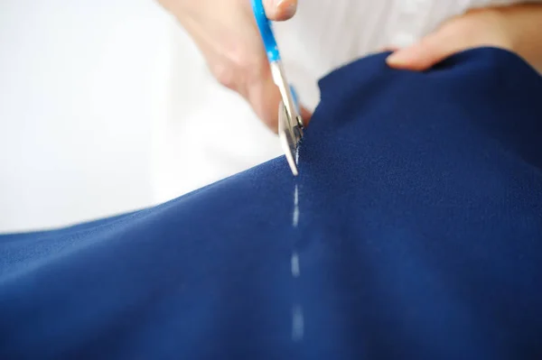 Tailoring of natural wool. Woman tailors sewing fabric.
