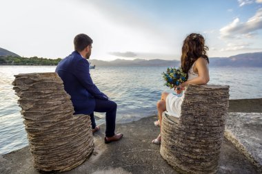 Genç evli çift gün batımı izliyor.